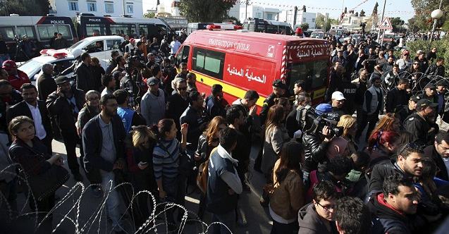 People surround an ambulance carrying the bodies of the victims of an attack by gunmen on Tunisia's national museum in Tunis