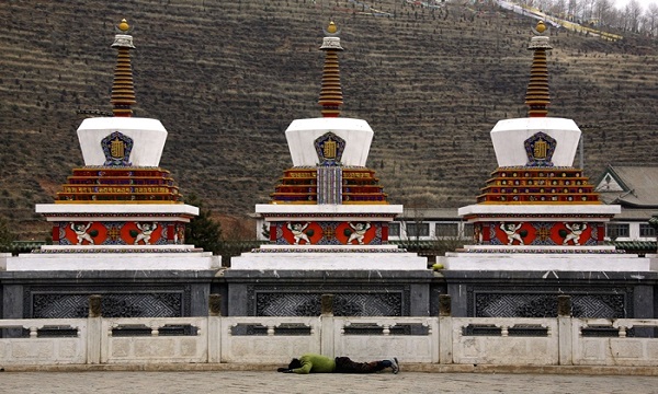 A Tibetan prays by lying flat on the ground in front of a shrine in the Kumbun Monastery located on the outskirts of Xining in Qinghai province