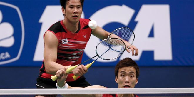 South Korea's Shin returns a shot as his partner Ko looks on during men's doubles semi-final match against South Korea's Lee and Yoo at the 2015 BCA Indonesia Open