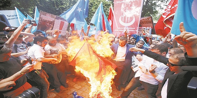 Demonstrators set fire to a Chinese flag during a protest against China near the Chinese Consulate in Istanbul