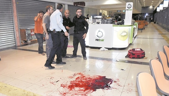 Israeli security personals stand next to blood on the floor, at the Beersheba central bus station where a Palestinian gunman went on a stabbing and shooting rampage