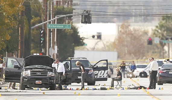 Police and Sheriff's Office Crime Scene Iinvestigators examine evidence at the scene of the investigation around an SUV where two suspects were shot by police following a mass shooting in San Bernardino