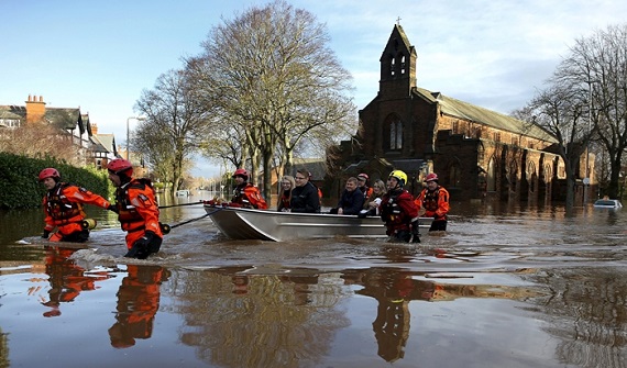 Rescue workers evacuate local residents by boat from a flooded residential street in Carlisle, Britain