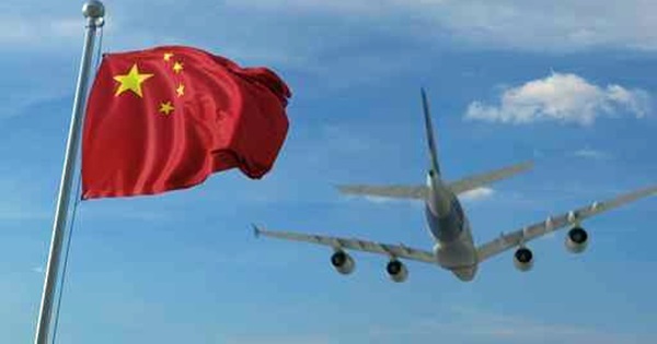 Commercial airplane landing behind waving Chinese flag. Travel t