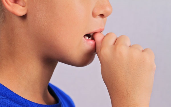 Nail biting child close up
