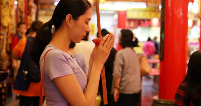 young-woman-praying-at-temple-royalty-free-i11mage-1658229872