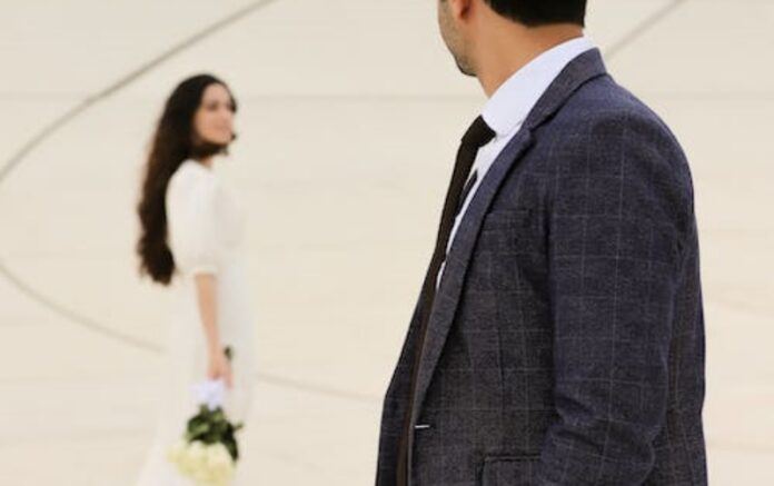 free-photo-of-well-dressed-man-looking-back-over-shoulder-on-woman-in-white-dress